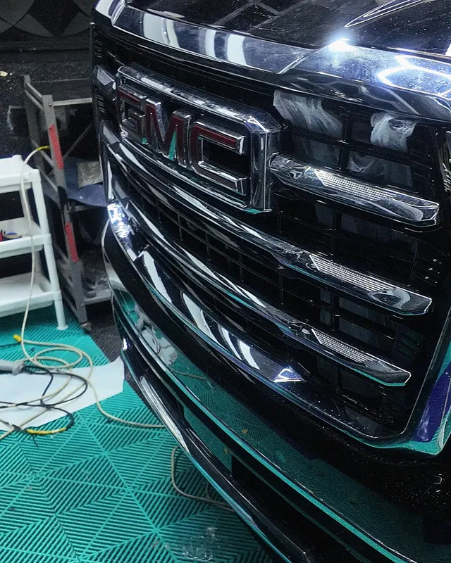 Chrome grille of a black 2025 GMC Yukon from a low angle, full-body clear gloss PPF at JU Riyadh Center