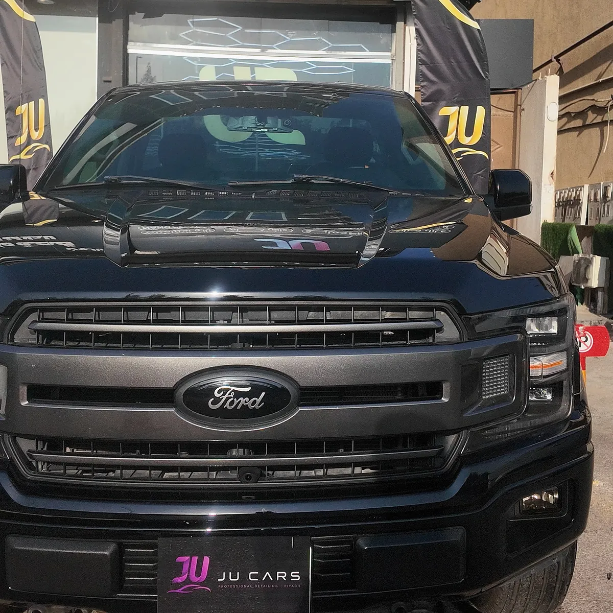 Whole front of the Ford F-150 outside JU Riyadh Center after its color change from white to gloss black with PPF film