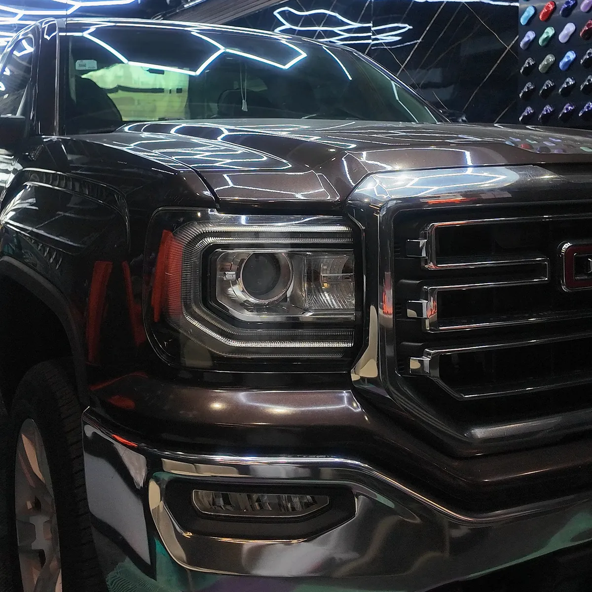 GMC Sierra in its original brown under the hexagon lights, before its color change to gloss black with PPF film at JU Riyadh Center