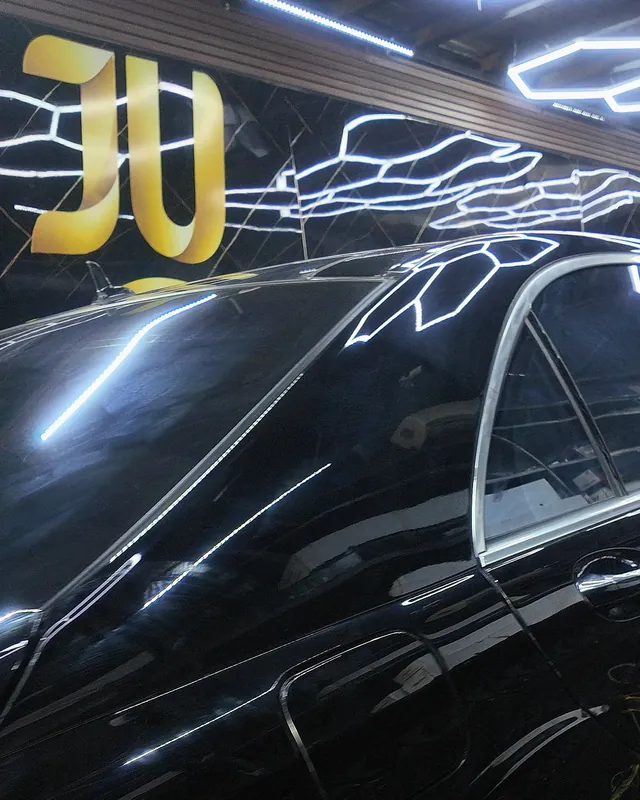 جانب مرسيدس S500 سوداء لامعة تحت الإضاءة السداسية خلال تركيب حماية PPF كاملة شفافة لامعة في مركز جي يو الرياض